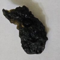 De grootte van deze tektiet fragment is 3 cm.